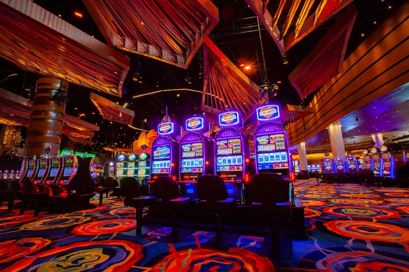 Fila de máquinas tragamonedas con carteles de jackpot en la sala principal del casino